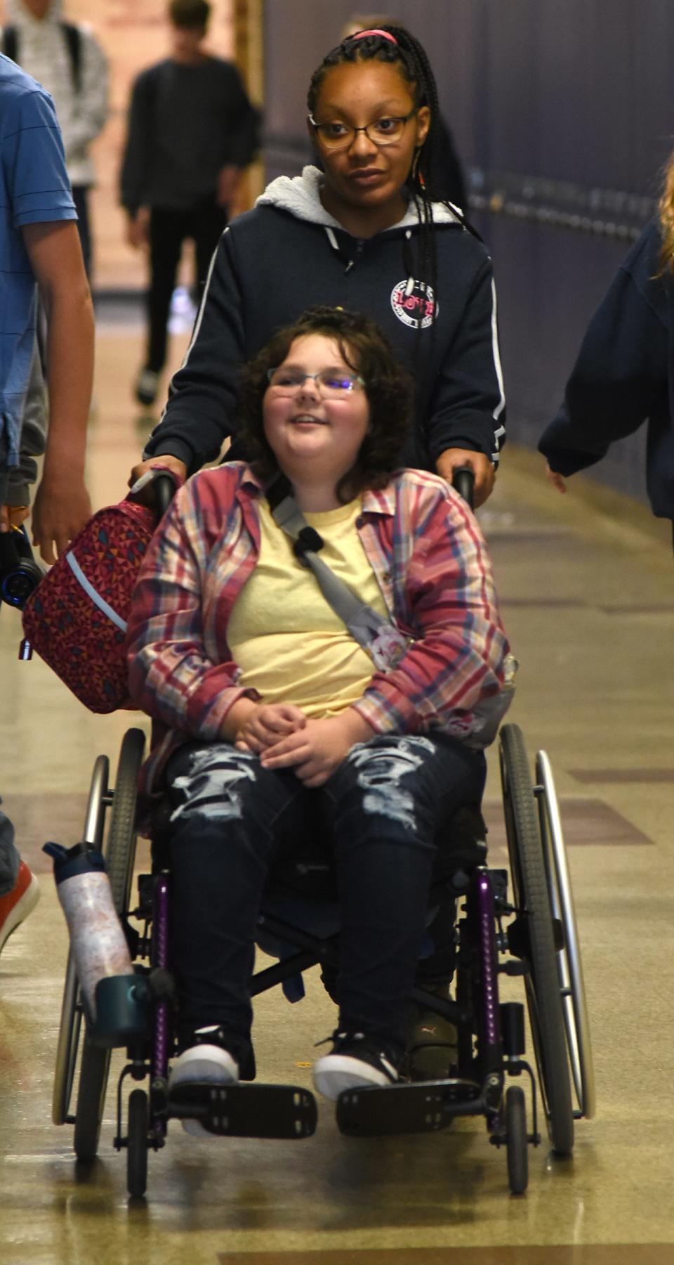 Wagar Middle School eighth grader Elly Wickenheiser, 13, of Carleton, is pushed to her next class by classmate Kathleen Calloway.