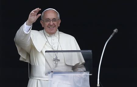 Pope Francis waves as he leads his Sunday Angelus prayer in Saint Peter's square at the Vatican May 18, 2014. REUTERS/Tony Gentile