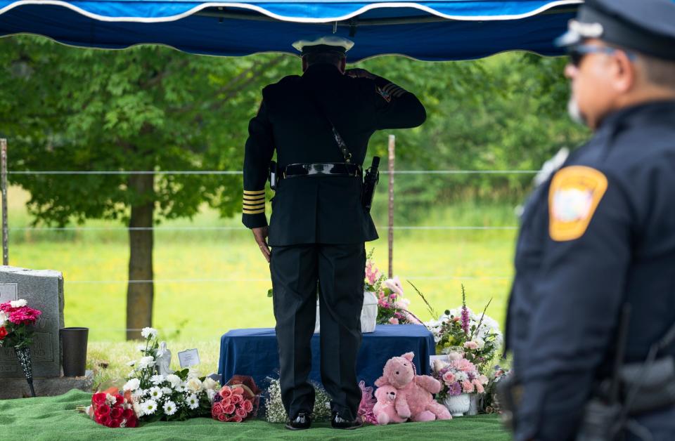 Plain City Police Chief Dale McKee salutes the tiny casket of "Madison Baby Doe," during her burial on June 24. The body of the unidentified infant was found in the trash on June 15.