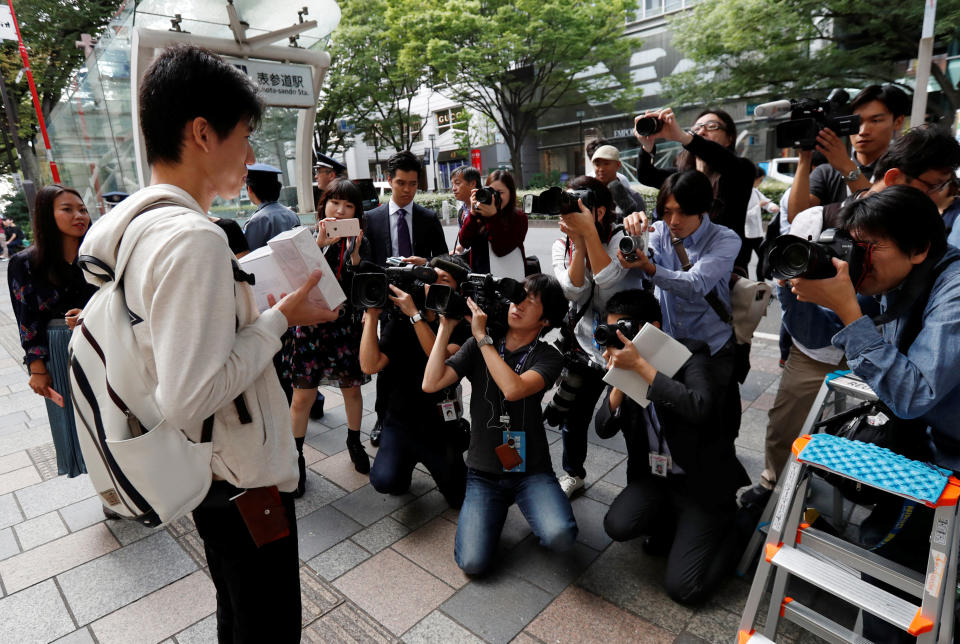 Yokoyama poses for the media with Apple’s new iPhone 8 Plus and new Apple Watch after purchasing them at the Apple Store in Tokyo’s Omotesando shopping district