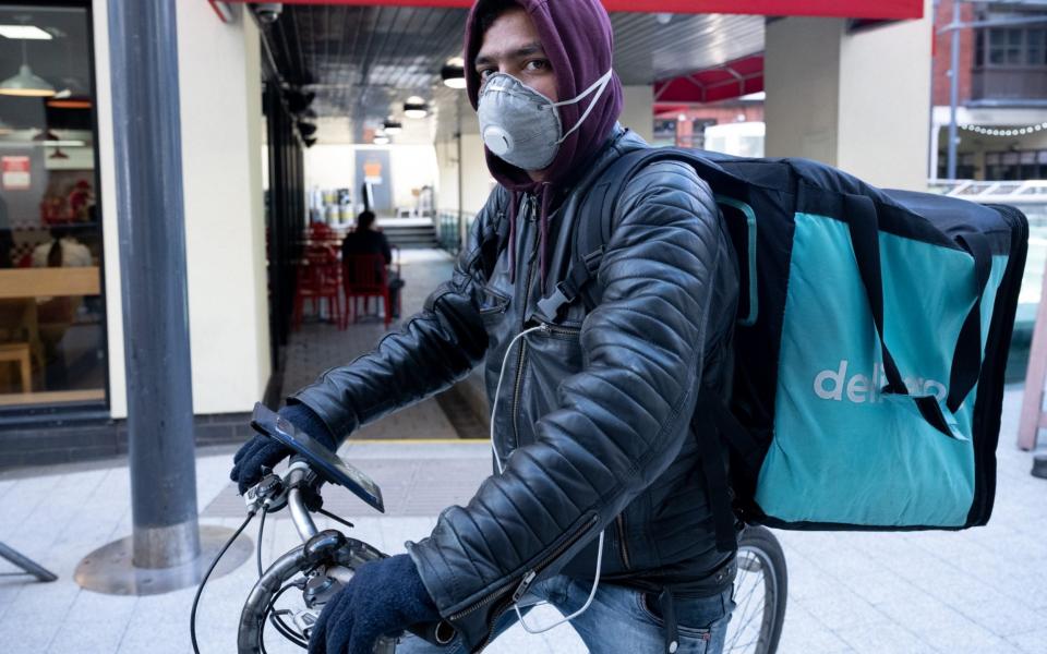 Deliveroo rider wears a surgical face mask in Cardiff city centre on March 8, 2020 - Matthew Horwood /Getty Images Europe