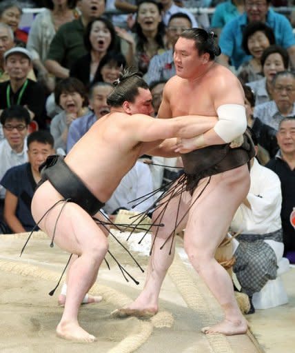 Mongolian-born champion, or "ozeki", Harumafuji (left) pushes his compatriot and grand champion, or "yokozuna", Hakuho (right), out of the ring to take the title at the Nagoya Grand Sumo tournament in July. 2012