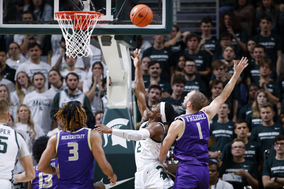 Michigan State's Tyson Walker, center, puts up a layup between James Madison's T.J. Bickerstaff, left, and Noah Freidel (1) during the first half of an NCAA college basketball game, Monday, Nov. 6, 2023, in East Lansing, Mich. (AP Photo/Al Goldis)