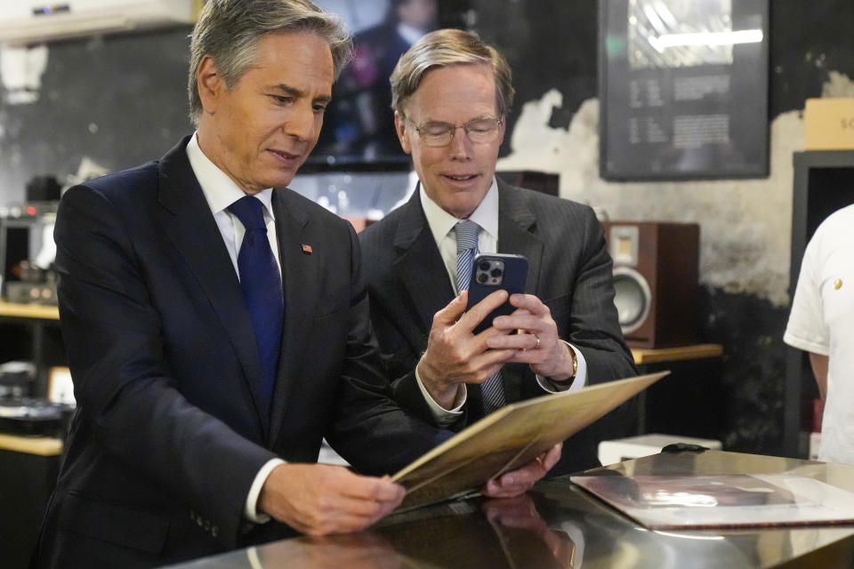 U.S. Secretary of State Antony Blinken and US ambassador to China Nicholas Burns look at a record during a visit to Li-Pi record store in Beijing, China, Friday, April 26, 2024. (AP Photo/Mark Schiefelbein, Pool)