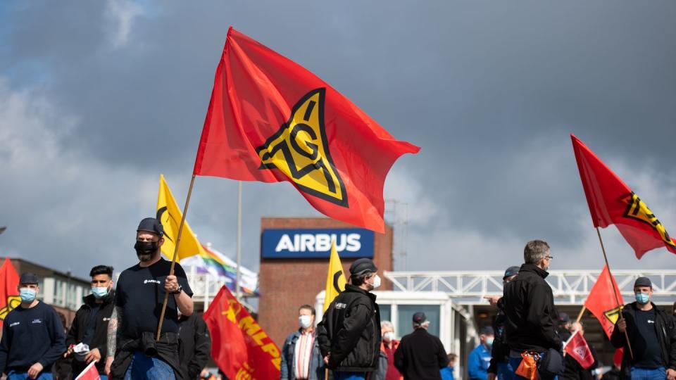 Beschäftigte des Airbus-Werkes in Finkenwerder schwenken Fahnen der IG Metall (Mai).