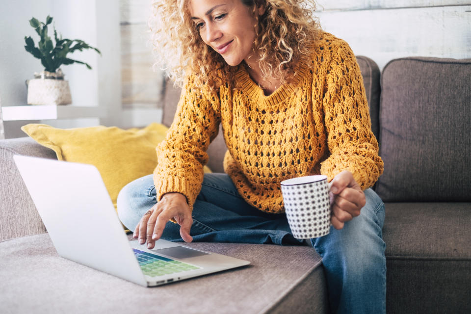 Woman in a yellow jumper online shopping