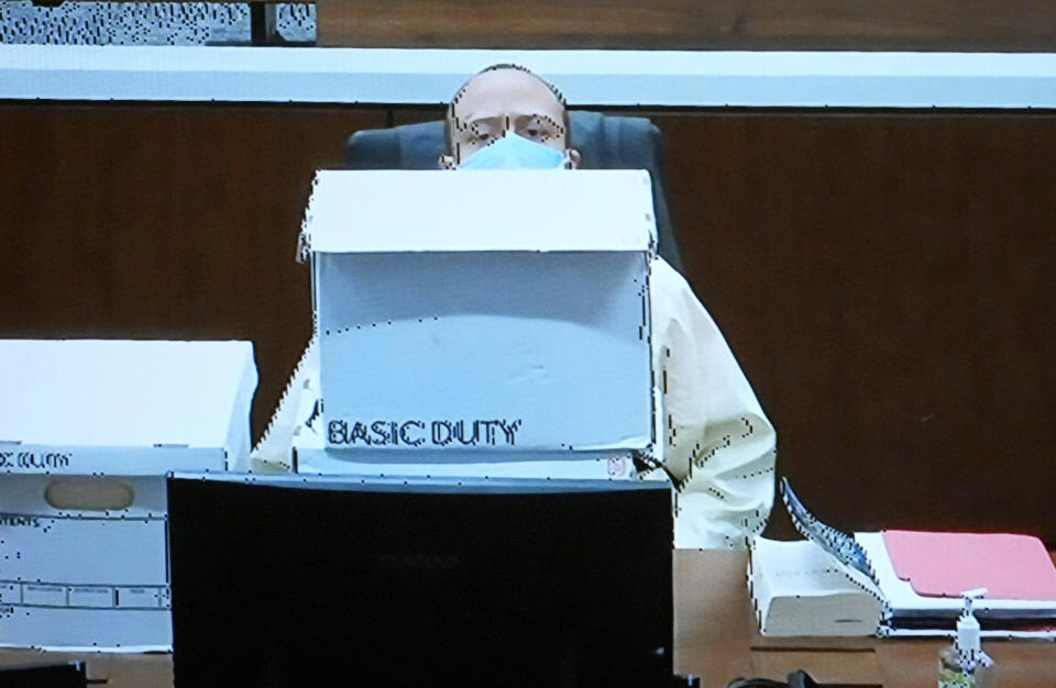 Darrell Brooks, appearing on video from an adjacent courtroom after being removed for being disruptive, sits behind his boxes of court documents as the court was reviewing jury instructions during his trial in a Waukesha County Circuit Court in Waukesha, Wis., on Monday, Oct. 24, 2022. Brooks, who is representing himself during the trial, is charged with driving into a Waukesha Christmas Parade last year, killing six people and injuring dozens more. (Mike De Sisti/Milwaukee Journal-Sentinel via AP, Pool)