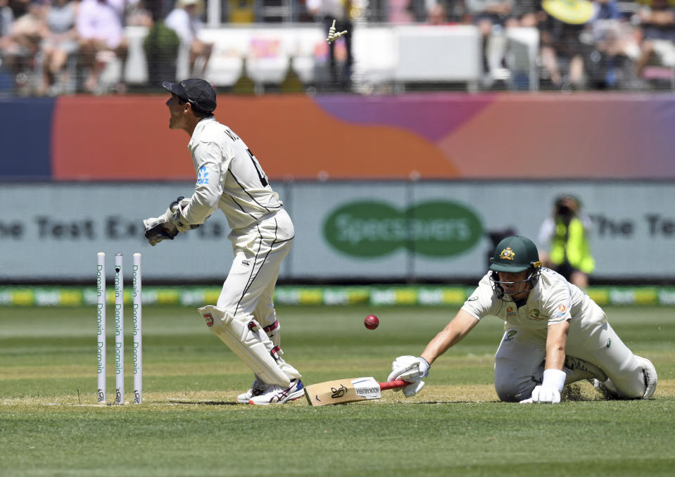 New Zealand's BJ Watling, left attempts to run out Australia's Marnus Labuschagne, right during play in their cricket test match in Melbourne, Australia, Thursday, Dec. 26, 2019. (AP Photo/Andy Brownbill)