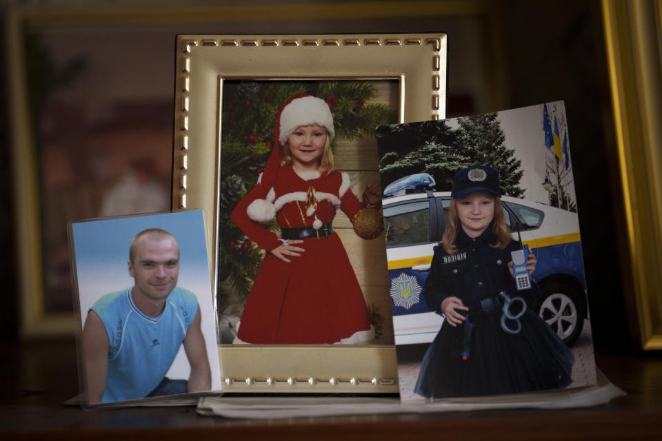 A picture of Sviatoslav Turovskyi, left, who was among eight men executed in a vacant lot in the suburb of Bucha in March 2022, sits on a shelve next to other relatives at his father's Oleksandr apartment in Bucha, Ukraine, Saturday, March 30, 2024. Days after Russian forces withdrew from the area in late March, in the dramatic first weeks of the full-scale invasion, a photo taken by AP Photographer Vadim Ghirda revealed what happened to the eight men. (AP Photo/Vadim Ghirda)