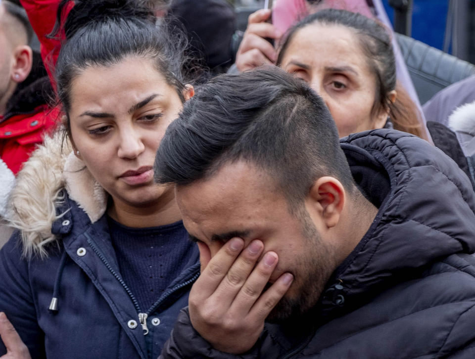 Friends of victims of a shooting in Hanau, Germany, gather on Friday, Feb. 21, 2020. A 43-year-old German man shot dead nine people of immigrant backgrounds in the Frankfurt suburb of Hanau on Wednesday night before killing his mother and himself. He left a number of rambling texts and videos espousing racist views. (AP Photo/Michael Probst)