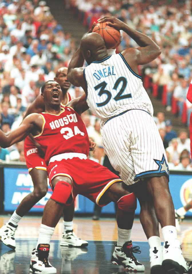 Shaquille O'Neal fouls Houston Rockets' Hakeem Olajuwon during first quarter action of game one of the NBA Championships in the Orlando Arena. (CALVIN KNIGHT/AFP/Getty Images)