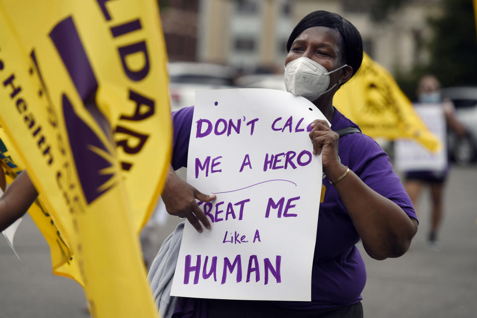 FILE - Clarissa Johnson of Hartford marches with long-term care members of the New England Health Care Employees Union, during a rally to demand new laws to protect long-term caregivers and consumers, July 23, 2020, at the State Capitol in Hartford, Conn. Connecticut essential state employees, who worked long hours during the COVID-19 pandemic, are still waiting for "hero pay" from $22.5 million in federal pandemic funds set aside in the state budget. (AP Photo/Jessica Hill, File)