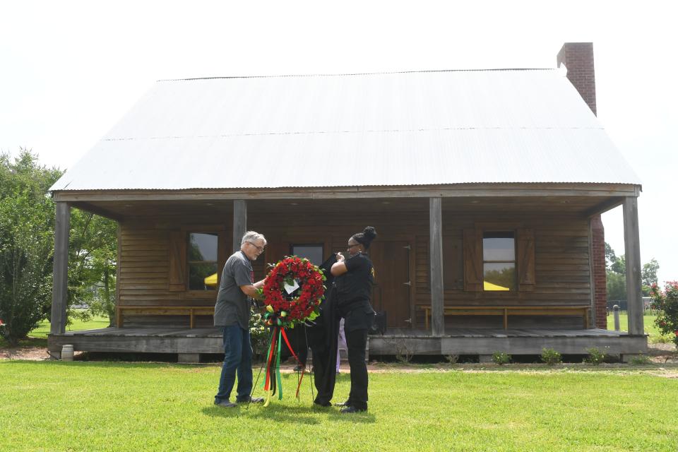 LSUA professor of English Bernard Gallagher (left) and LSUA police officer and graphic design student Mechelle Williams place a wreath at the Edwin Epps House, a symbol of slavery,  in memorial to enslaved people.