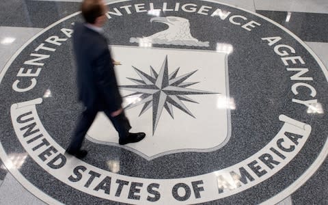 A man crosses the Central Intelligence Agency logo in the lobby of CIA Headquarters in Langley, Virginia - Credit: SAUL LOEB/AFP/Getty Images