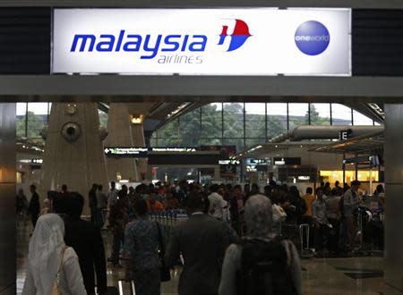 Passengers queue up at the Malaysia Airlines ticketing booth at the Kuala Lumpur International Airport in Sepang March 9, 2014. REUTERS/Edgar Su