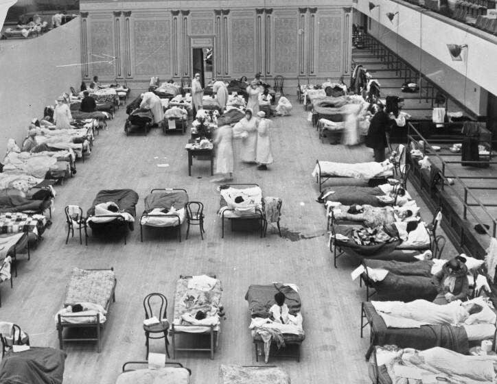 Volunteer nurses from the American Red Cross tend to influenza patients in the Oakland Municipal Auditorium in 1918,