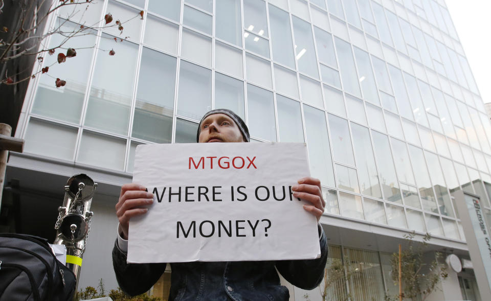 Kolin Burges, a self-styled cryptocurrency trader and former software engineer who came from London, holds a placard to protest against Mt. Gox, in front of the building where the digital marketplace operator is housed in Tokyo February 25, 2014. The website of Mt. Gox appears to be taken down, shortly after six major Bitcoin exchanges released a joint statement distancing themselves from the troubled Tokyo-based bitcoin exchange. Tokyo-based Mt. Gox was a founding member and one of the three elected industry representatives on the board of the Bitcoin Foundation. REUTERS/Toru Hanai (JAPAN - Tags: BUSINESS CIVIL UNREST SCIENCE TECHNOLOGY)