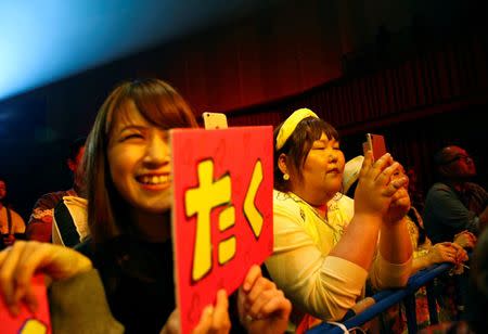 Women watch models posing on the runway during Tokyo Pocchari collection, Japan's first fashion show for plump men in Tokyo. REUTERS/Kim Kyung-Hoon