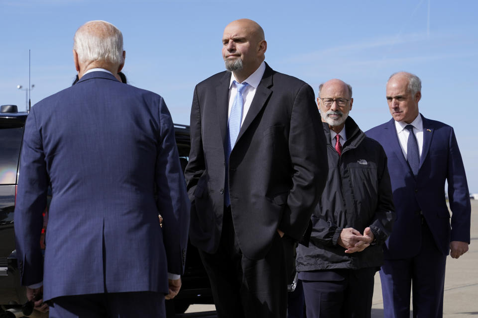 Pennsylvania Lt. Gov. John Fetterman, center, a Democratic candidate for U.S. Senate, stands on the tarmac after greeting President Joe Biden, front left, Thursday, Oct. 20, 2022, at the 171st Air Refueling Wing at Pittsburgh International Airport in Coraopolis, Pa. Biden is visiting Pittsburgh to promote his infrastructure agenda. (AP Photo/Patrick Semansky)