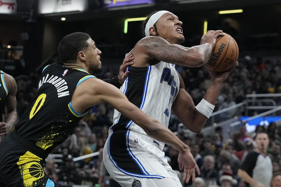 Orlando Magic's Paolo Banchero is fouled by Indiana Pacers' Tyrese Haliburton (0) during the first half of an NBA basketball game Saturday, Dec. 23, 2023, in Indianapolis. (AP Photo/Darron Cummings)