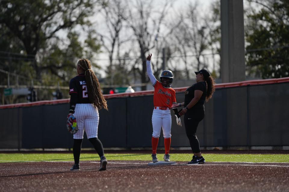 Florida A&M Rattlers outfielder Neriah Lee celebrates on first base alongside assistant coach Jane'a Mobley during a home game against the Texas Tech Raiders on Friday, February 9, 2024. It was FAMU's first time hosting an opening day game since 2015.