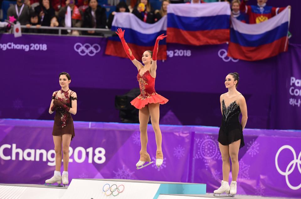 <p>Bronze medallist Canada’s Kaetlyn Osmond (R), and silver medallist Russia’s Evgenia Medvedeva (L) look on as gold medallist Russia’s Alina Zagitova celebrates on the podium during the venue ceremony after the women’s single skating free skating of the figure skating event during the Pyeongchang 2018 Winter Olympic Games at the Gangneung Ice Arena in Gangneung on February 23, 2018. / AFP PHOTO / Roberto SCHMIDT </p>