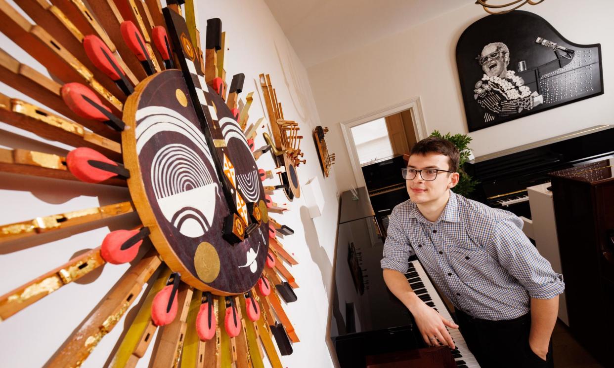 <span>Sales assistant Tom Wyeth with a mask sculpture by Victoria Topping and an Elton John piano lid by Kirk Andrews.</span><span>Photograph: Sam Frost/The Guardian</span>