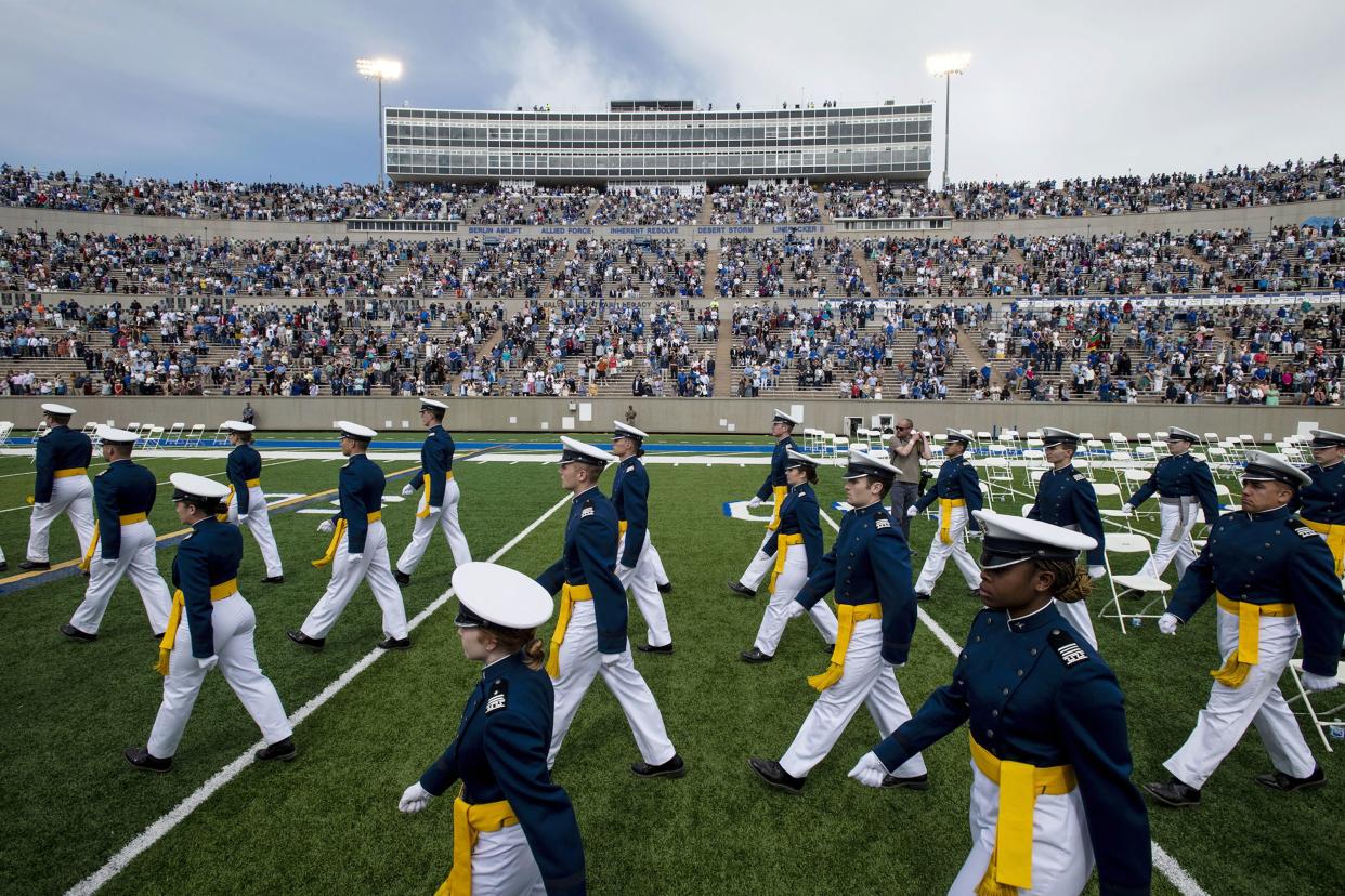 Air Force Academy cadets make their way to their seats as family and friends cheer from the stands during the graduation ceremony at the USAFA in Colorado Springs, Colo., on May 26, 2021.