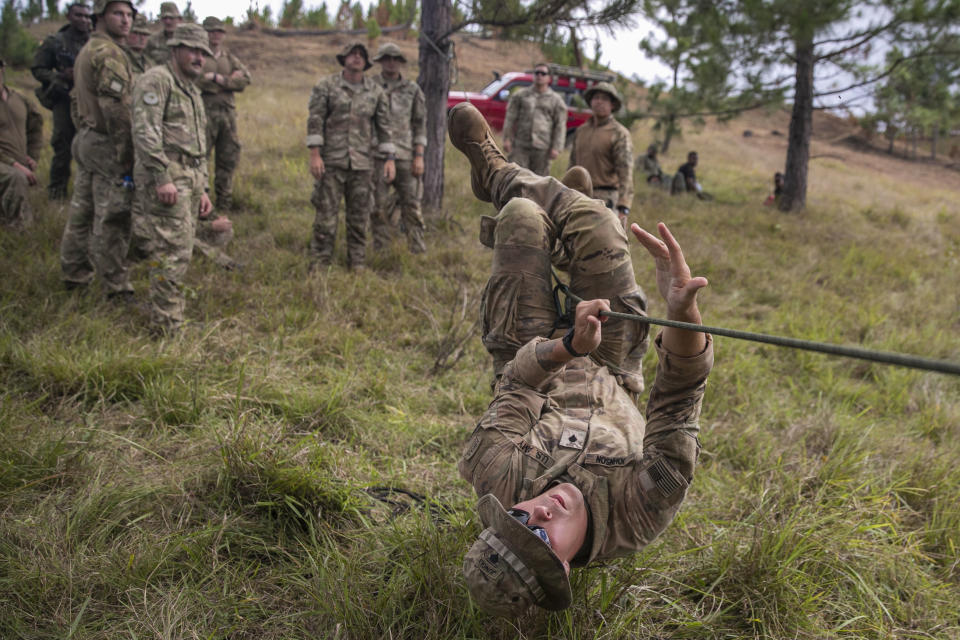 In this photo provided by U.S. Navy, U.S. Army Spc. Daniel Johnson, an infantryman with Bravo Company, 2nd Battalion, 27th Infantry Regiment, 3rd Infantry Brigade Combat Team, 25th Infantry Division, demonstrates how to cross a single rope bridge with the hand-over-hand method during Exercise Cartwheel, Nadi, Fiji, on Sept. 18, 2022. A military exercise in Fiji involving the United States, Britain, Australia and New Zealand ends this week as the traditional allies counter China’s growing influence in the region.(Sgt. 1st Class Andrew Guffey/U.S. Navy via AP)