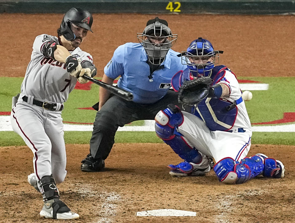 FILE - Arizona Diamondbacks' Corbin Carroll, left, hits an RBI single against the Texas Rangers during the seventh inning in Game 2 of the baseball World Series, Oct. 28, 2023, in Arlington, Texas. Baltimore Orioles infielder Gunnar Henderson and Carroll were unanimous selections for Rookies of the Year, Monday, Nov. 13, 2023, with Henderson winning the American League honor and Carroll earning the National League award. (AP Photo/Tony Gutierrez, File)