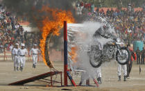 A policeman performs a stunt through fluorescent tubes and a ring of fire during the Republic Day celebrations in Jammu January 26, 2011. India celebrated its 62nd Republic Day on Wednesday. REUTERS/Mukesh Gupta