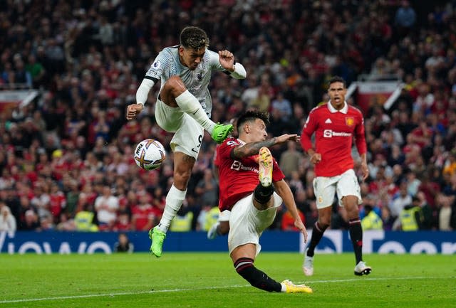 Lisandro Martinez, right, blocks a shot from Liverpool's Roberto Firmino