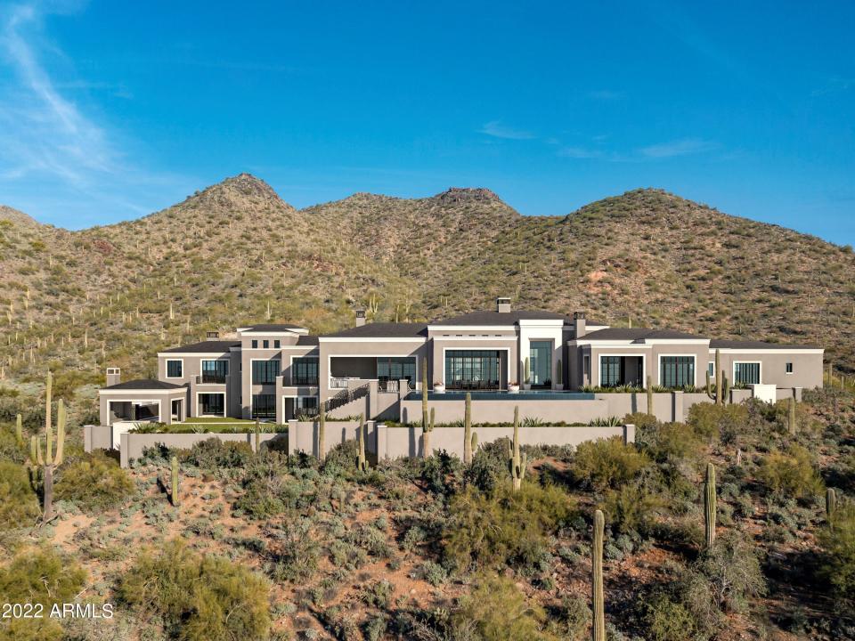 a home surrounded by mountains and cacti in Arizona