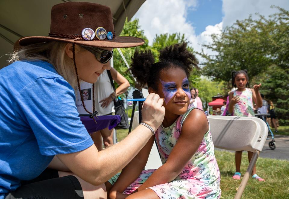 Kalani Norman gets her face painted by Clarissa Summers, an educator at the Taylor School District, at Heritage Park during the 175th anniversary of Taylor on Aug. 6, 2022. Norman's parents own Norman Cafe in Romulus near Taylor.