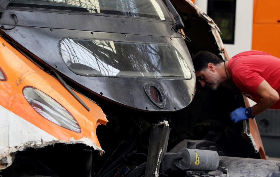 <p>A worker looks at the front of a commuter train after it ran into the buffers on the platform of a train station in Barcelona, Spain, Friday July 28, 2017. (Photo: Adrian Quiroga/AP) </p>