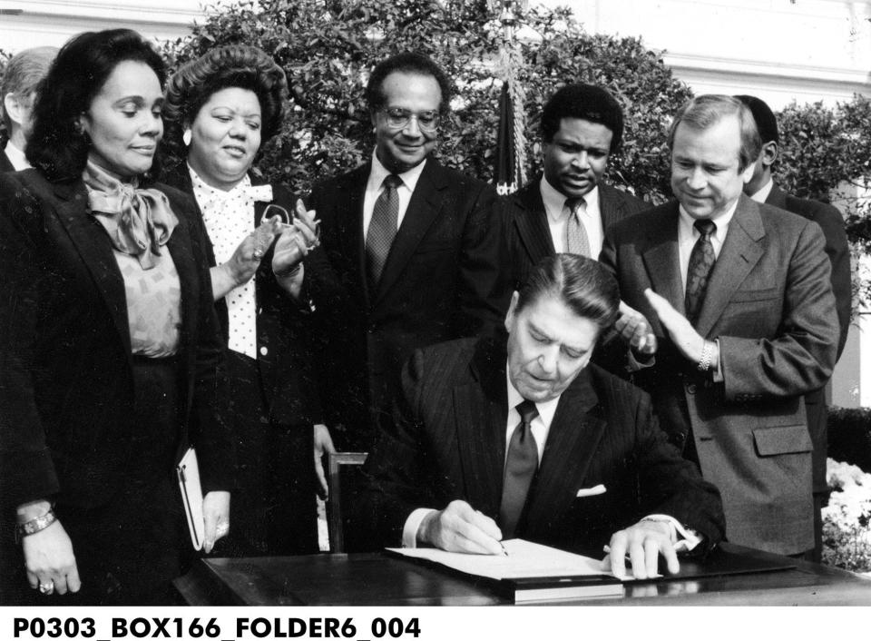 Nov. 2, 1983, Rep. Katie Hall (second from left) witnesses President Ronald Reagan signing bill to nationalize Martin Luther King Jr. holiday.
