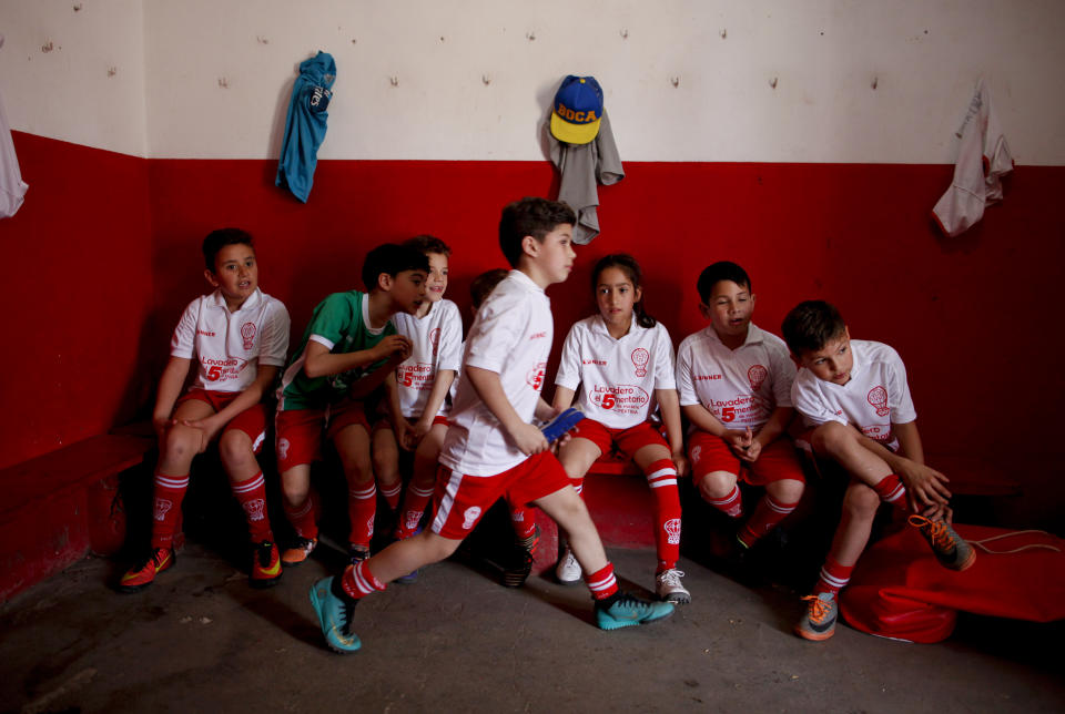 In this Sept. 8, 2018 photo, Candelaria Cabrera, third from right, sits with her teammates before a match against the Alumni soccer team, in Chabas, Argentina. Two months ago, the regional soccer authorities notified Huracan that the team could no longer include Candelaria. (AP Photo/Natacha Pisarenko)