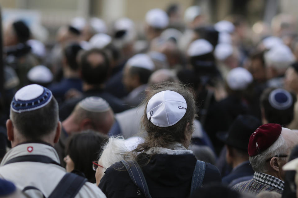 FILE - In this Wednesday, April 25, 2018 file photo people wear Jewish skullcaps, or kippa, as they attend a demonstration against an anti-Semitic attack in Berlin, Germany. A new survey says about one in four Europeans hold anti-Semitic beliefs, with such attitudes on the rise in eastern countries and mostly steady in the west. (AP Photo/Markus Schreiber, file)