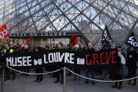 Striking employees demonstrate with a banner reading "Louvre museum on strike" outside the Louvre museum, Friday, Jan. 17, 2020 in Paris. Paris' Louvre museum was closed Friday as dozens of protesters blocked the entrance to denounce the French government's plans to overhaul the pension system. (AP Photo/Francois Mori)