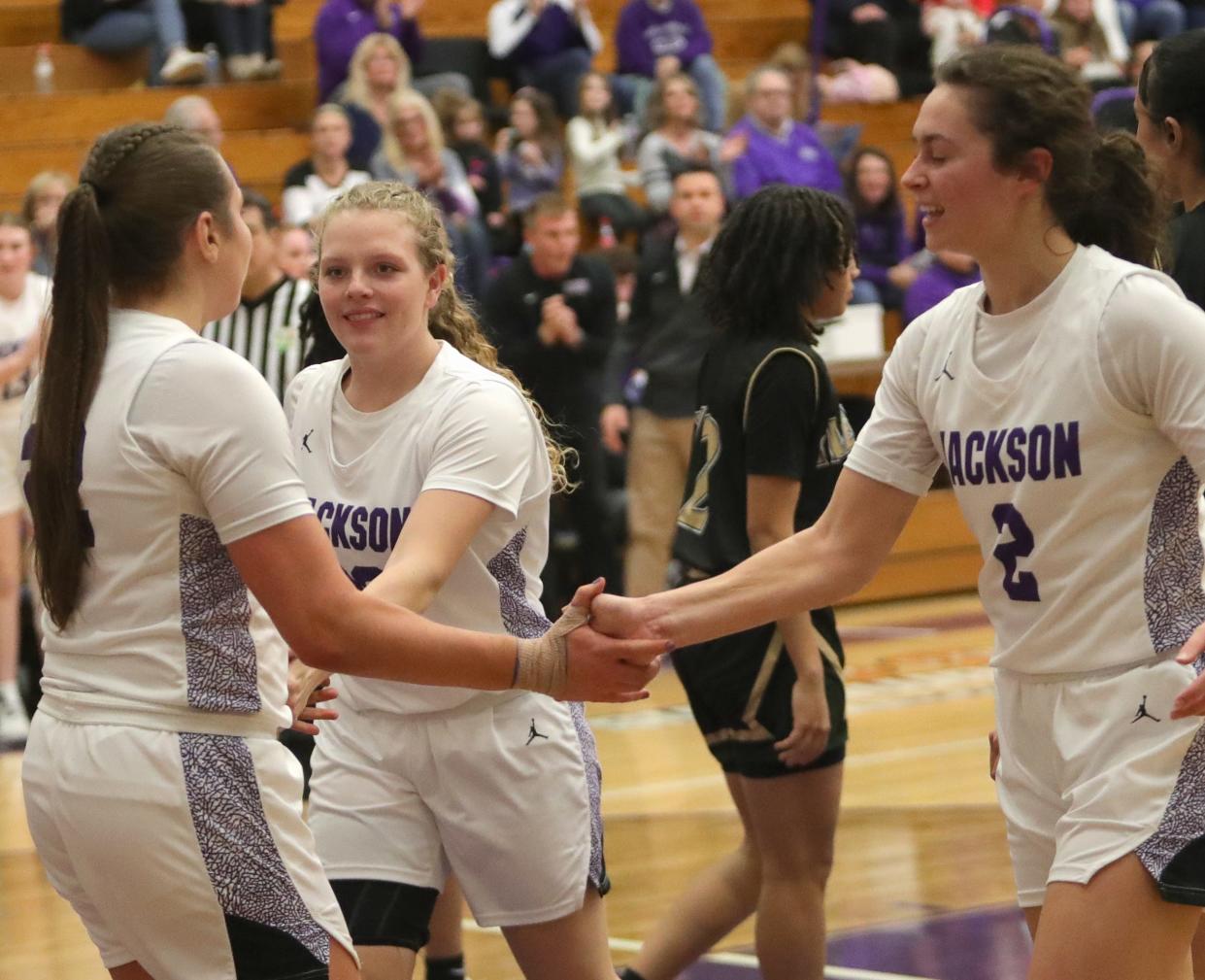 Jackson's (from left) Megan Campbell, Lexi Pizor and Ashley Lahmers celebrate after Campbell's late basket against GlenOak, Friday, Dec. 22, 2023.