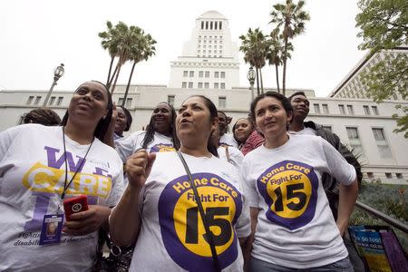 A group of women stand on the steps of City Hall after the Los Angeles City Council approved a proposal to increase the minimum wage to $15.00 per hour in Los Angeles, California June 3, 2015. REUTERS/Jonathan Alcorn