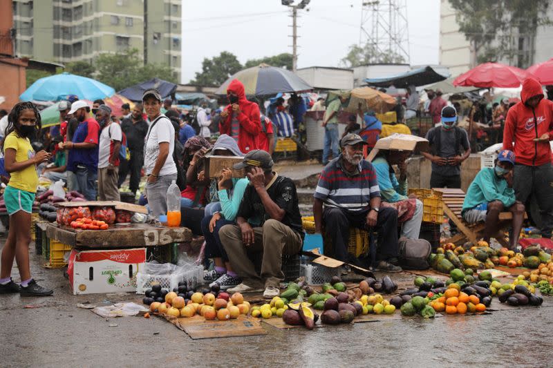 Sellers wait for customers under the rain at the Coche wholesale market amid coronavirus (COVID-19) disease outbreak in Caracas