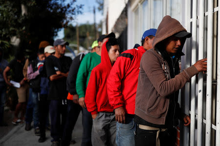 Migrants, part of a caravan traveling en route to the United States, queue to receive food outside a sport center that is currently used as a temporary shelter in Tijuana, Mexico November 16, 2018. REUTERS/Carlos Garcia Rawlins