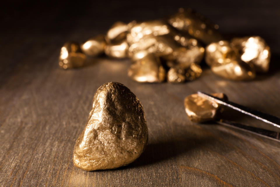 Gold nuggets on a wooden table.