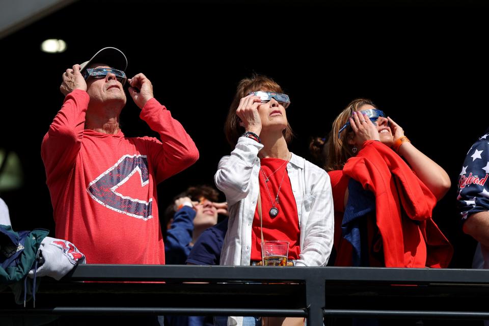 Cleveland Guardians fans look up at the solar eclipse before the home opener against the Chicago White Sox at Progressive Field on April 08, 2024 in Cleveland, Ohio.