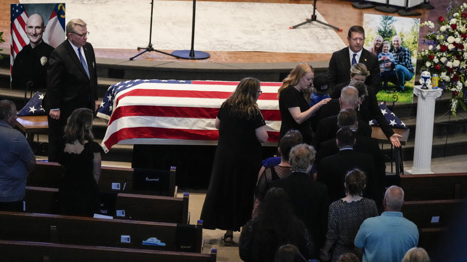 Family and friends are seated during a memorial service for Officer Joshua Eyer, Friday, May 3, 2024, in Charlotte, N.C. Police in North Carolina say a shootout that killed Eyer and wounded and killed other officers began as officers approached a home to serve a felony warrant on Monday. (AP Photo/Chris Carlson)