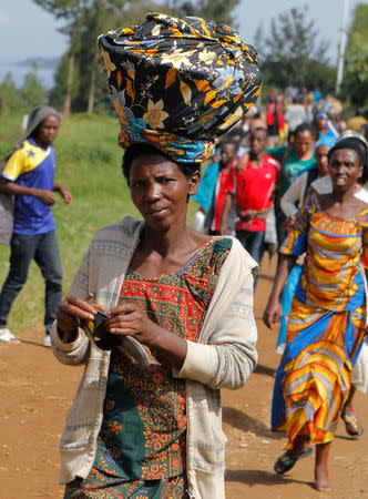 Refugees from the Democratic Republic of Congo carry their belongings as they walk near the the United Nations High Commissioner for Refugees (UNHCR) offices in Kiziba refugee camp in Karongi District, Rwanda February 21, 2018. REUTERS/Jean Bizimana