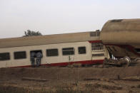 Security forces look inside a passenger train that derailed injuring some 100 people, near Banha, Qalyubia province, Egypt, Sunday, April 18, 2021. At least eight train wagons ran off the railway, the provincial governor's office said in a statement. (AP Photo/Fadel Dawood)