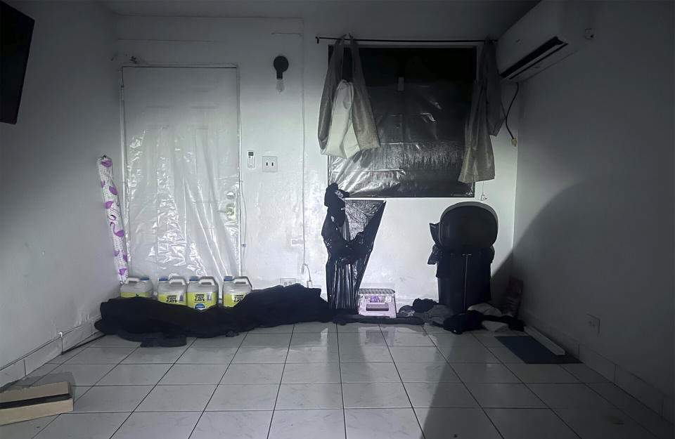 In this photo provided by Scottie Catherine McCorsley, plastic sheeting and various items are placed around the window and door of McCorsley's apartment in an attempt to contain floodwaters in Tamuning, Guam, Thursday, May 25, 2023, as Typhoon Mawar passes over the island. Guam residents and officials emerged from homes and shelters Thursday to survey the damage done to the U.S. Pacific territory after a long night of hunkering down as Typhoon Mawar's howling winds shredded trees, flipped vehicles and knocked out utilities. (Scottie Catherine McCorsley via AP)