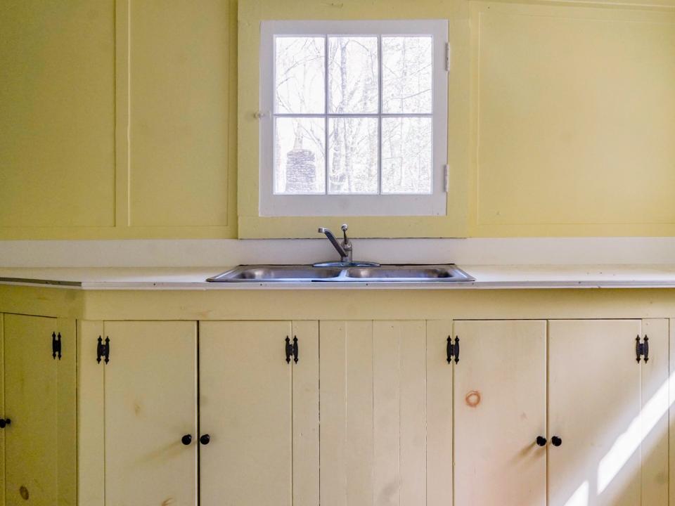 A sink and faucet in a kitchen with a window above it